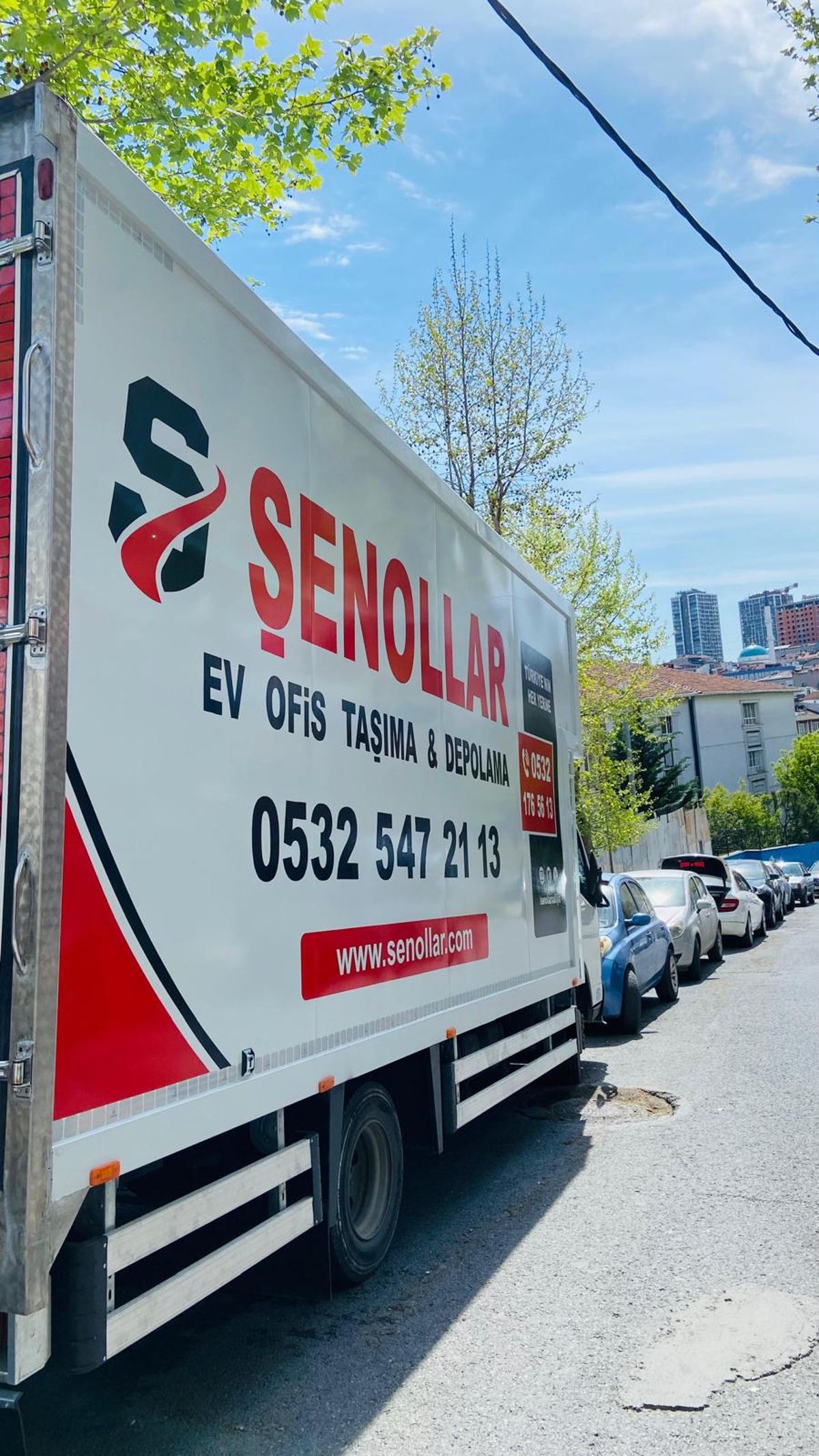 Şenollar kamyonu şehir manzarası önünde yola hazır